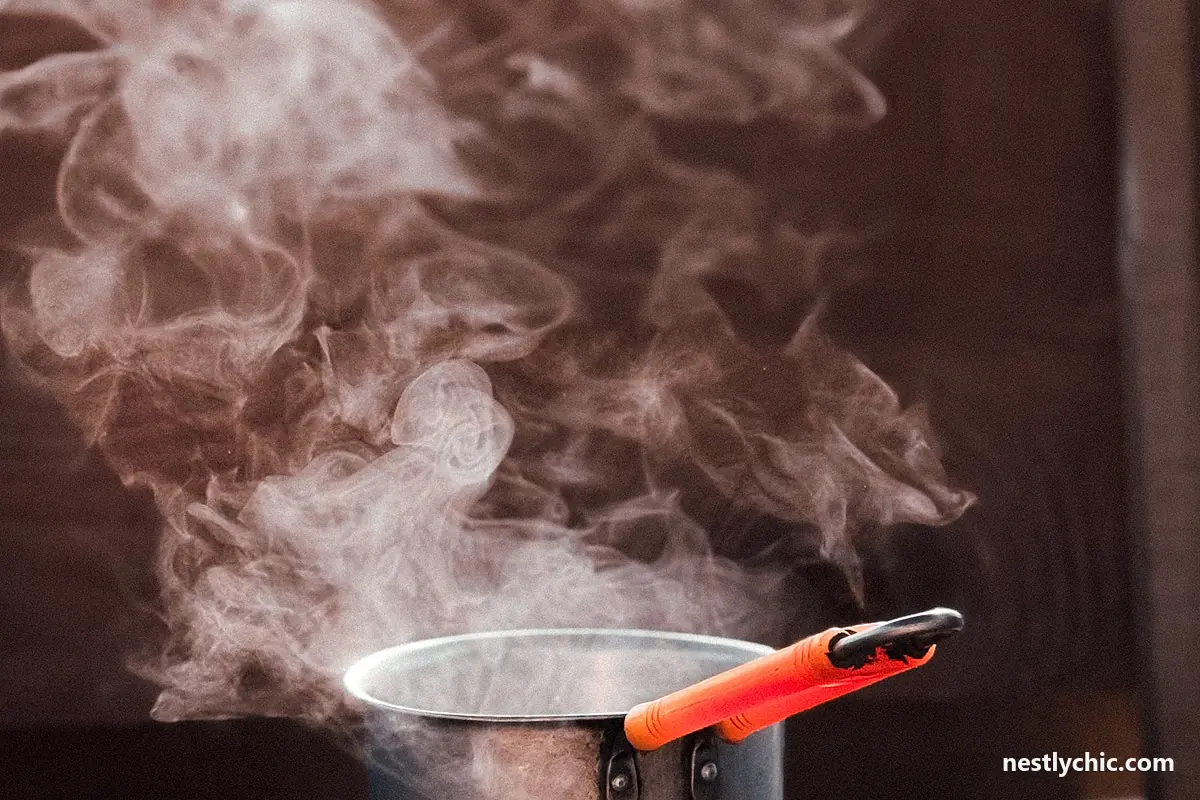 A metal saucepan with steam rising on a stove