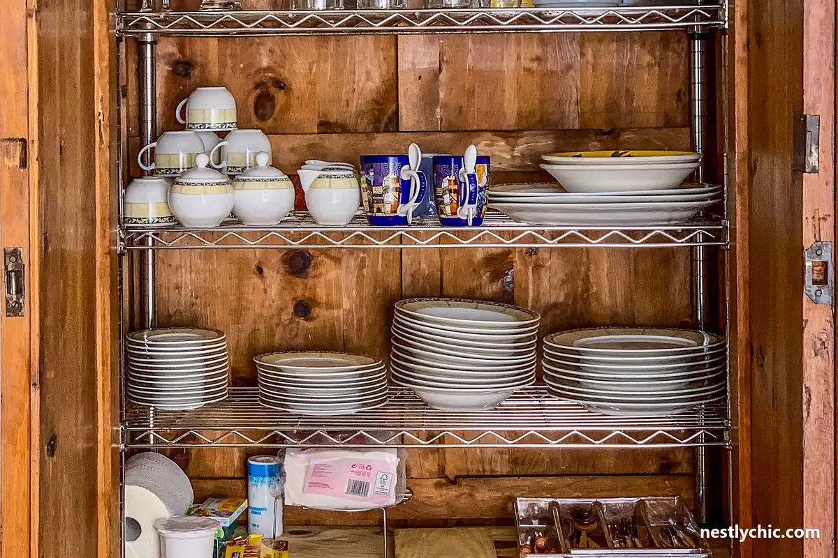 A kitchen cabinet of dishes and glassware still in good condition