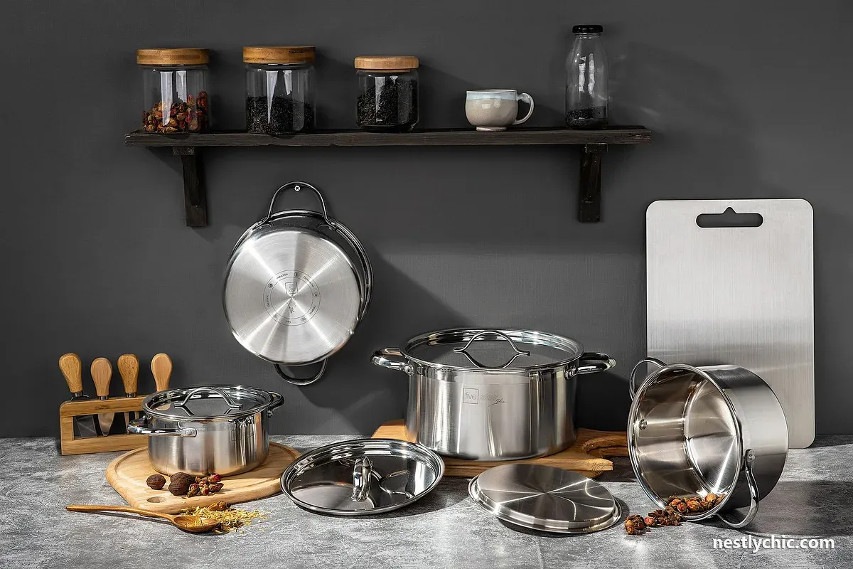 Stainless steel pots and kitchen essentials on a concrete surface