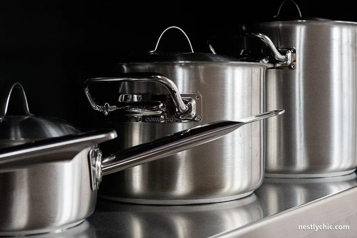 Stainless steel pots and pans on a dark background