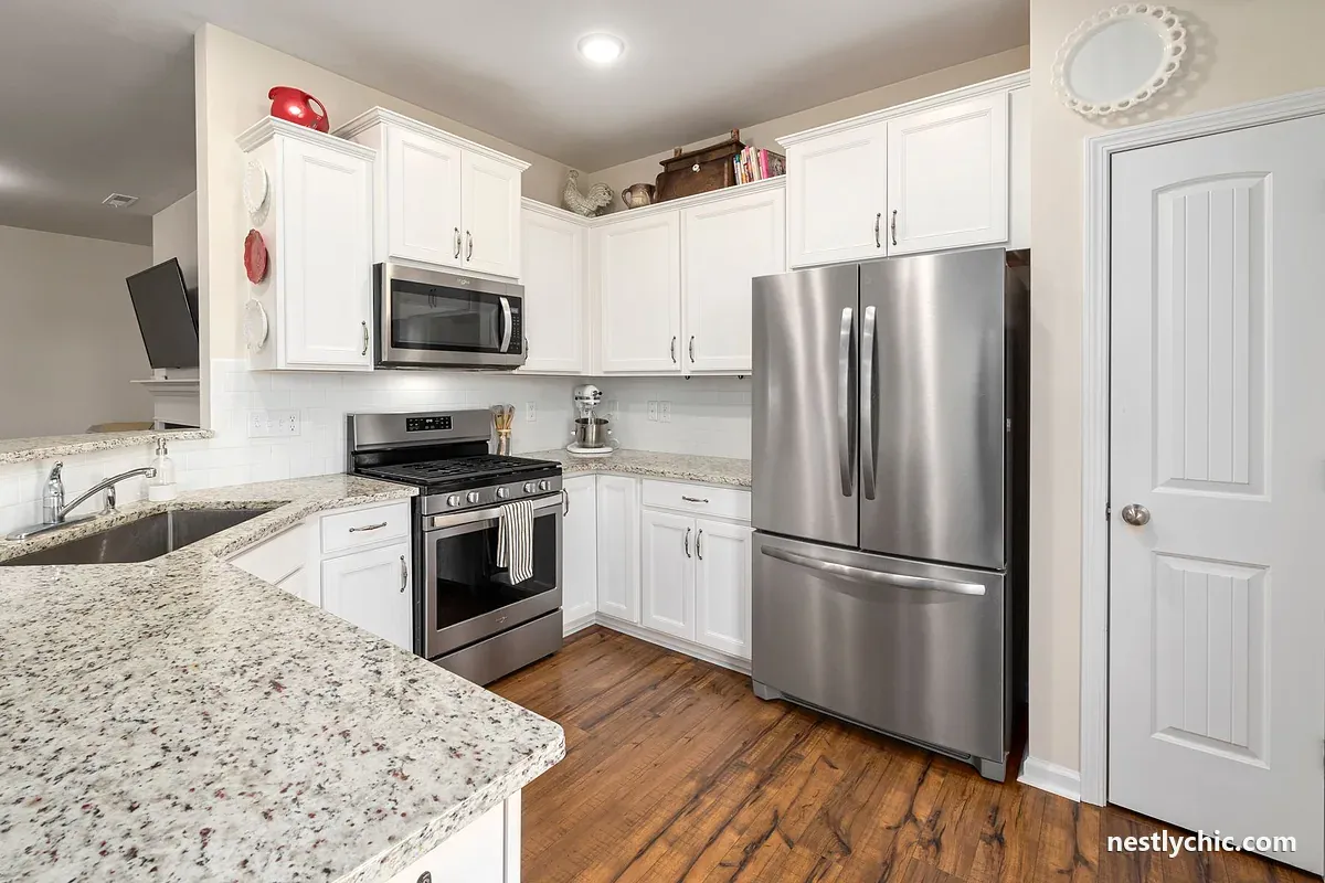 White kitchen with a stainless steel refrigerator