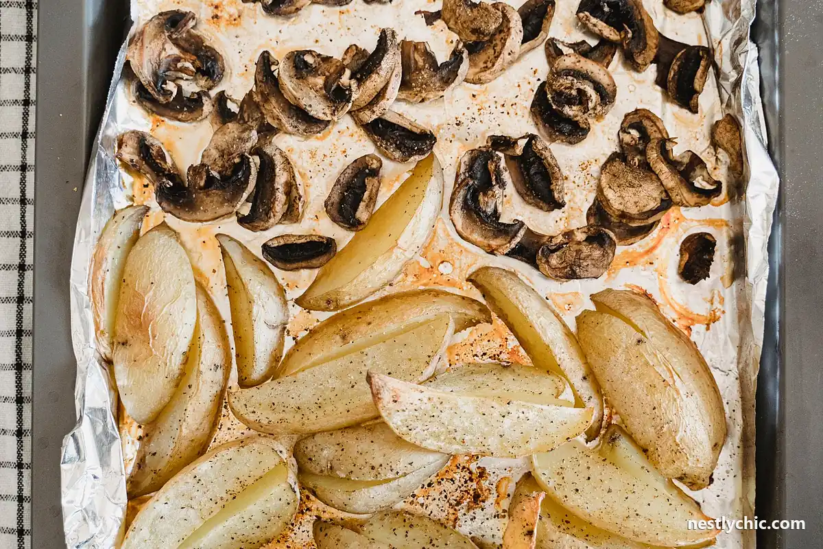 Roasted potato wedges and mushrooms on a metal tray