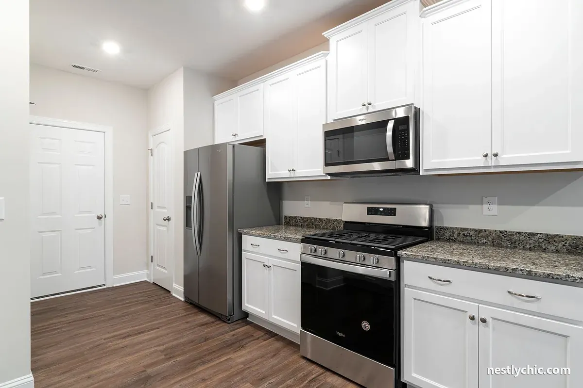 Stainless steel fridge set into white cabinets